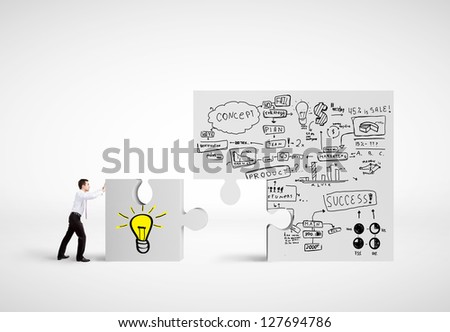 businessman moving puzzle with drawing business plan