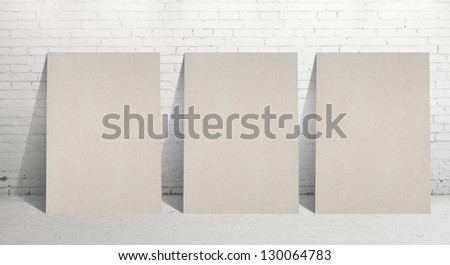 three paper stand and  brick wall