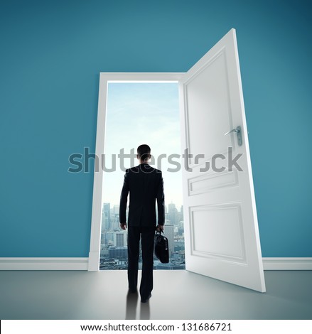 man with briefcase and open door to city