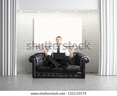 businessman with laptop sitting on sofa in loft