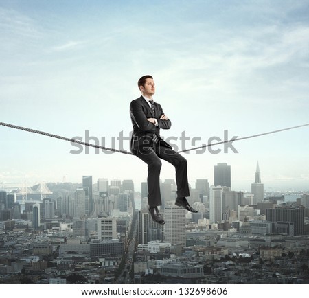 Businessman Sitting On Rope And City