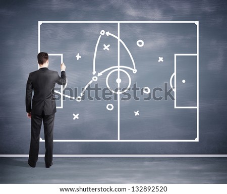 man drawing tactic scheme on big black desk board