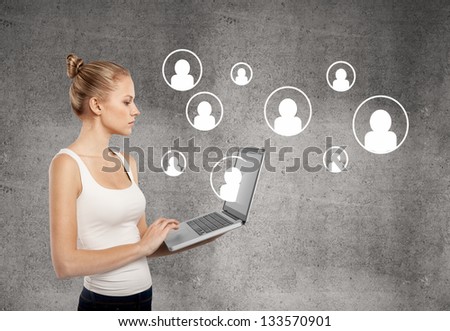 lady standing with laptop on concrete wall background