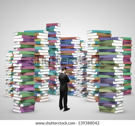 businessman thinking and looking at stacks of books