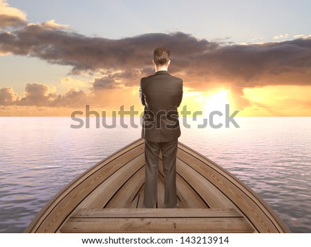 businessman standing on a boat and looking on sunset