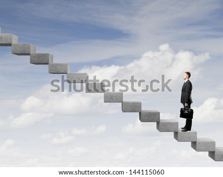 Businessman stepping up a staircase and sky