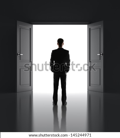Businessman Standing In Front Of Opened Doors