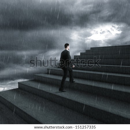 businessman climbing stairs in bad weather