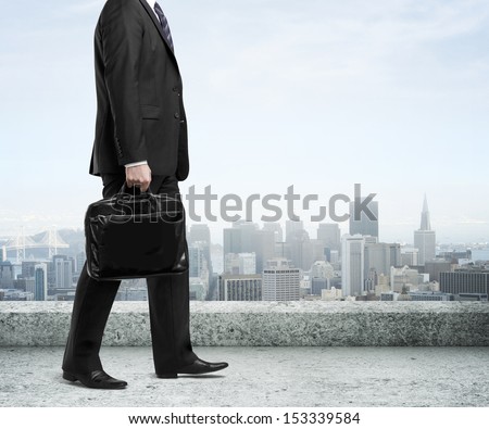 businessman with briefcase walking on concrete roof
