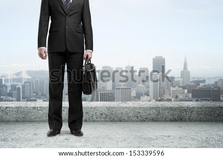 businessman with briefcase standing  on concrete roof