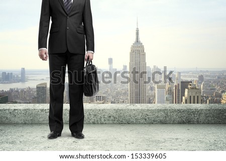 man with briefcase standing  on concrete roof