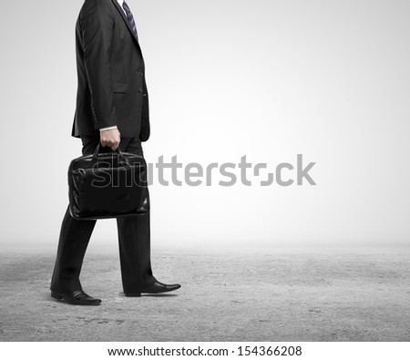 businessman walking with briefcase on concrete floor