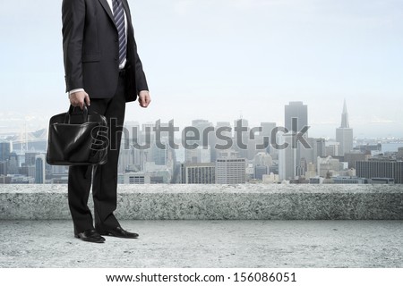man standing with briefcase on concrete roof