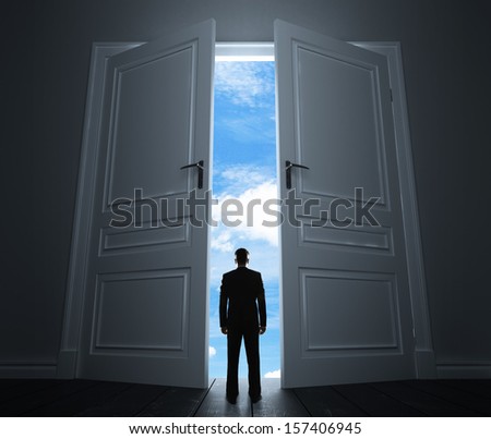 young man in room with big door to sky