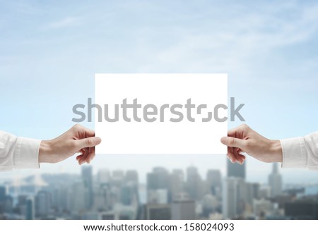 hands holding poster on city background
