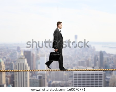 businessman walking on a rope over the city