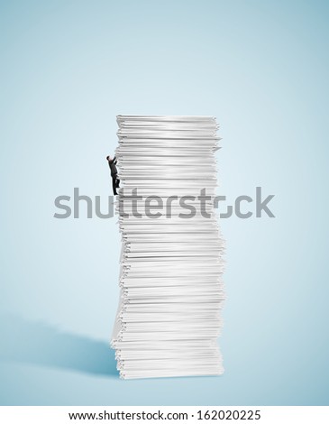young businessman climbing up a huge big stack of paper