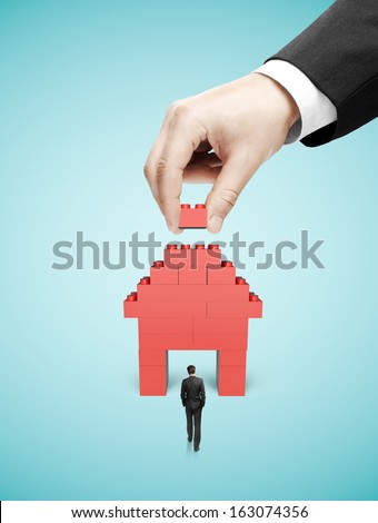 walking businessman and hand build house blocks