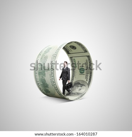 businessman walking in money wheel on gray background