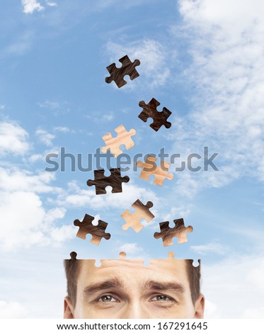 head man built of puzzle on sky background