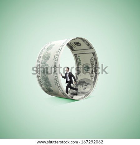 businessman running in money wheel  on green background