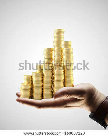 hand holding gold coins city on gray background