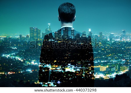 Businessman looking at illuminated night city. Double exposure