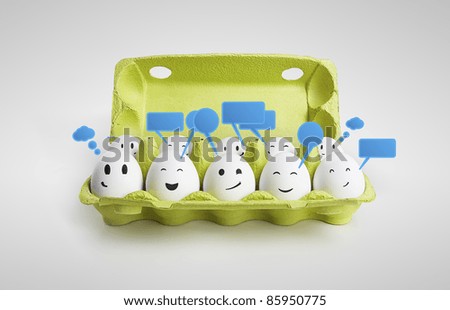 Group of happy smiling eggs with social chat sign and speech bubbles Ten white eggs in a carton box representing a social network On a gray background Group of happy smiling eggs with social chat sign and speech bubbles Ten white eggs in a carton box representing a social network On a gray background
