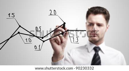 Young business man drawing a graph on a glass window in an office - focus is on graph. Businessman drawing a rising arrow, representing business growth.