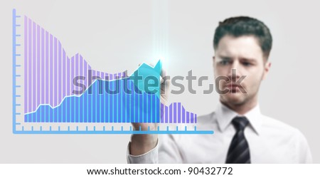 Young business man drawing a rise graph on a glass window in an office - focus is on graph. Businessman drawing a rising arrow, representing business growth. Man coming up with an idea