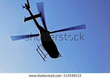 Generic silhouette of an helicopter caught  in flight against a clear blue sky. Actual location was Kashmir India but could have been taken anywhere on the globe