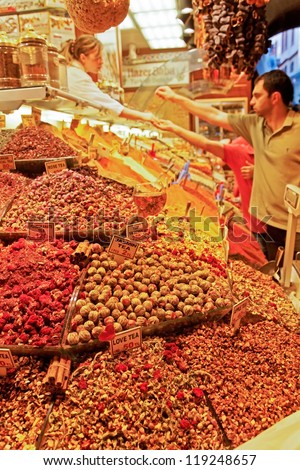 GRAND BAZAAR, ISTANBUL - JUNE 24, 2011: Busy trading scene at a herbal tea, dried fruit and spice stall with customers buying from seller on June 24, 2011 at the Grand Bazaar, Istanbul, Turkey.