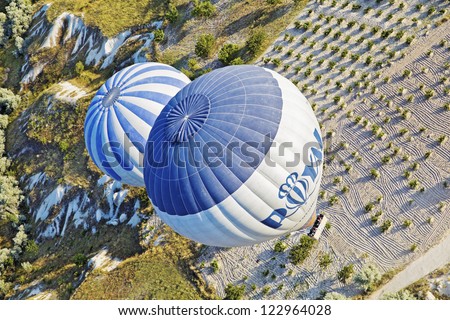 CAPPADOCIA, TURKEY - JUNE, 29: Diagonal aerial view of two hot air balloons on a low level passenger flight path over the limestone agricultural land on June 29, 2011 in Cappadocia, Turkey.