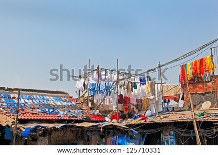 Denim drying on slate roofs and clothes in hand made bamboo racks at commercial laundry in Bombay India