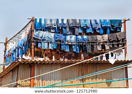 Denim Jeans washed and hanging out to dry in the hot Indian mid day sun at a commercial washing factory, Dhobhi Ghat. Location of shot Bombay India