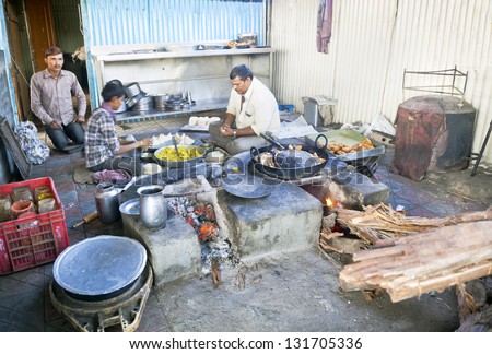 ALUNG, GUJARAT, INDIA - JAN, 16: Kitchen and staff at greasy cafe dhabha (Indian roadside cafe) preparing and frying samosas under extreme condition on January 26, 2013 in Gujarat, India