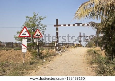 Landscape in Gujarat India of typical Indian railway crossing in the hinterlands. Lack of safety without barriers and generally the gravel road is used by bullock carts and public