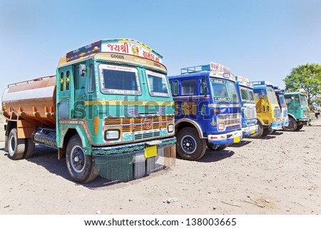 GUJARAT, INDIA - FEBRUARY 28, 2013: Colorful Indian heavy goods vehicles at  Dhabha (Indian truck stop) clean, tidy and colorful parked while crew take a rest on February 28, 2013 in Gujarat, India