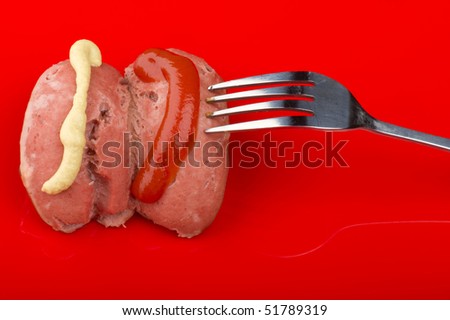 object on red - food frankfurter with ketchup and mustard