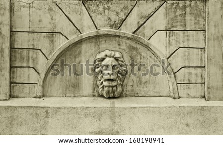 A lion\'s head on the wall of the old fountain for drinking
