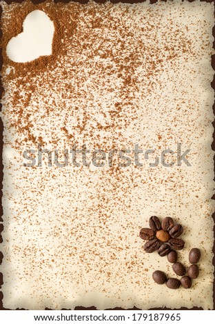 Heart made of ground coffee and flower made of coffee beans on a vintage burnt paper