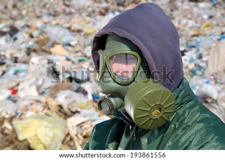 Man in a gas mask against polluted nature