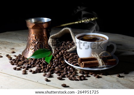 Hot Black Coffee in Coffee Pot and White Coffee Cup with Coffee Beans on Black Background