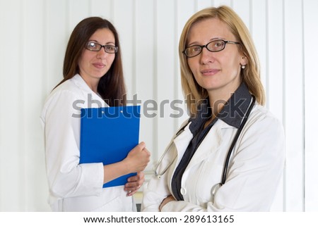 Portrait of Two Middle Age Female Doctors Smiling and Looking at Camera, Half-Length Shot