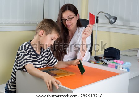 Female Doctor Examining Little Boy's Logical Thinking With Colored Geometric Shapes in Consulting Room