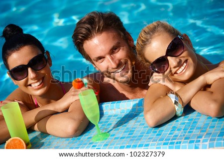 Happy young people on holiday, smiling in swimming pool.