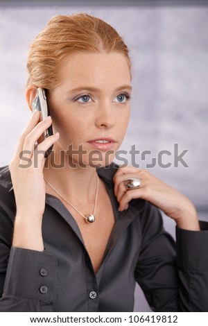 Closeup portrait of young businesswoman concentrating on mobile phone call.