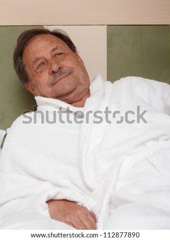 Portrait of elderly man in bathrobe, relaxing.