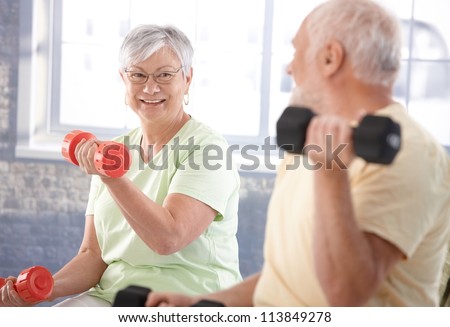 Vital Senior Couple Exercising In The Gym.