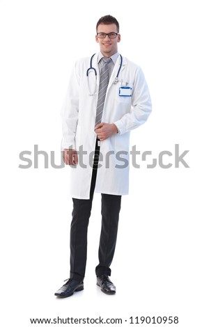 Young male doctor smiling confidently, wearing lab coat.